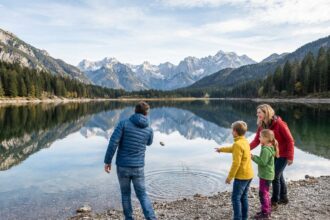 Famille de quatre au bord d'un lac alpin en montagne