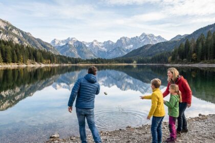 Famille de quatre au bord d'un lac alpin en montagne