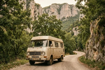 Van aménagé garé dans les gorges de l'Ardèche entouré de falaises calcaires et de végétation méditerranéenne
